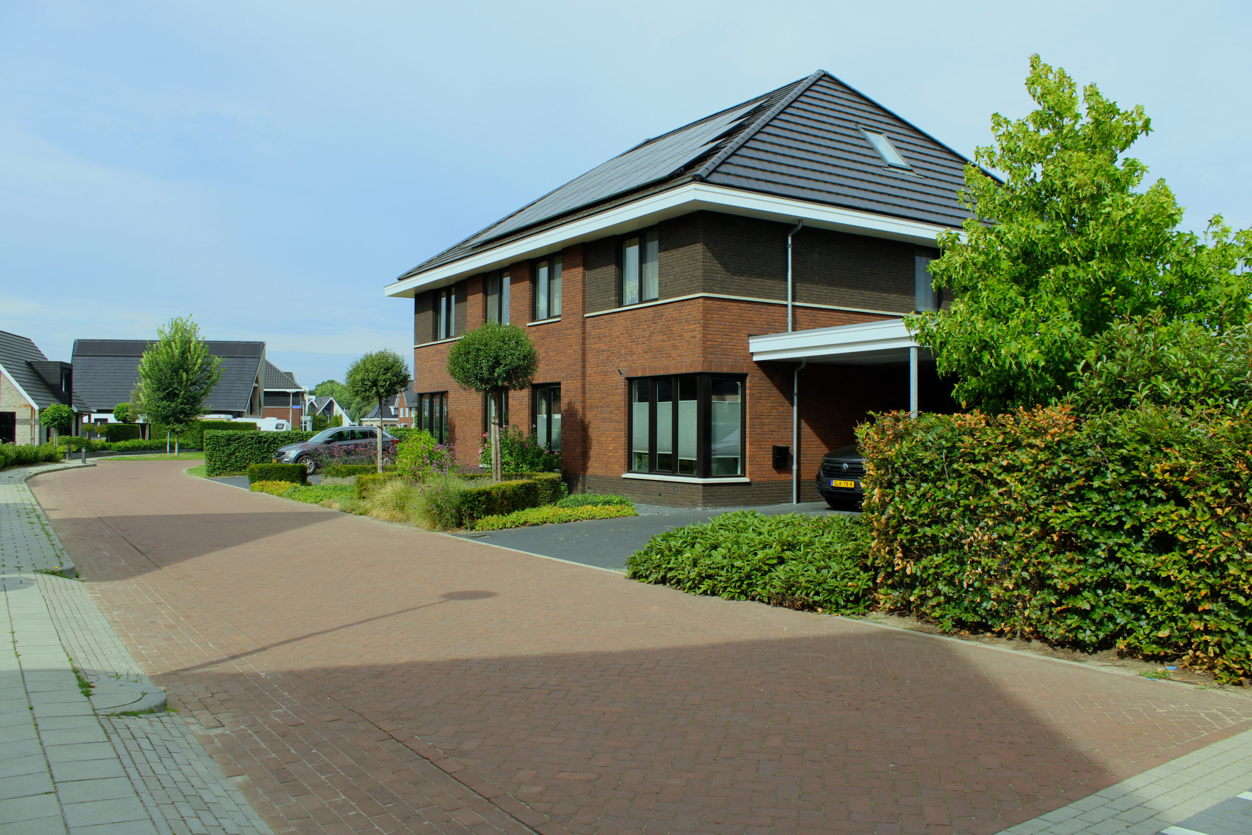 Twee-onder-een-kapwoning met rode bakstenen gevel, schilddak en verzorgde tuin