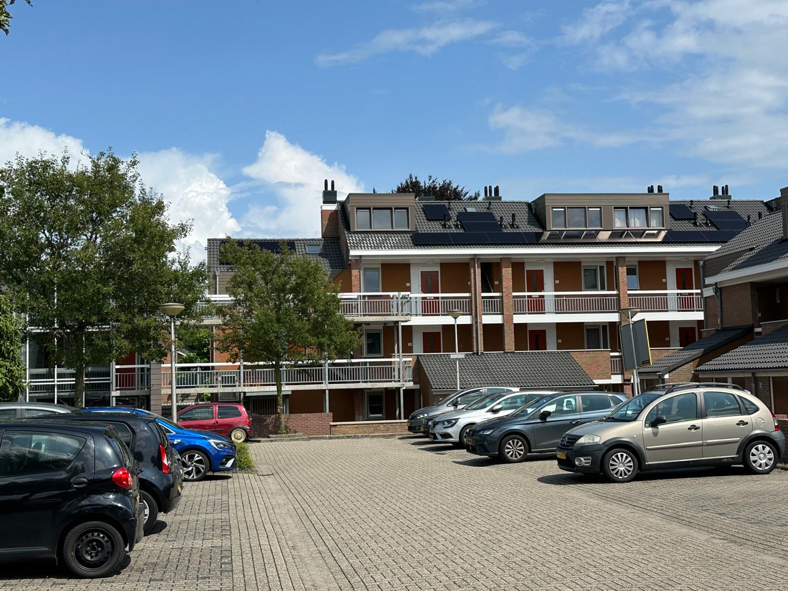 Appartementencomplex aan de Thoomsenweg in Neede met vernieuwde gevel en parkeerterrein na renovatie.