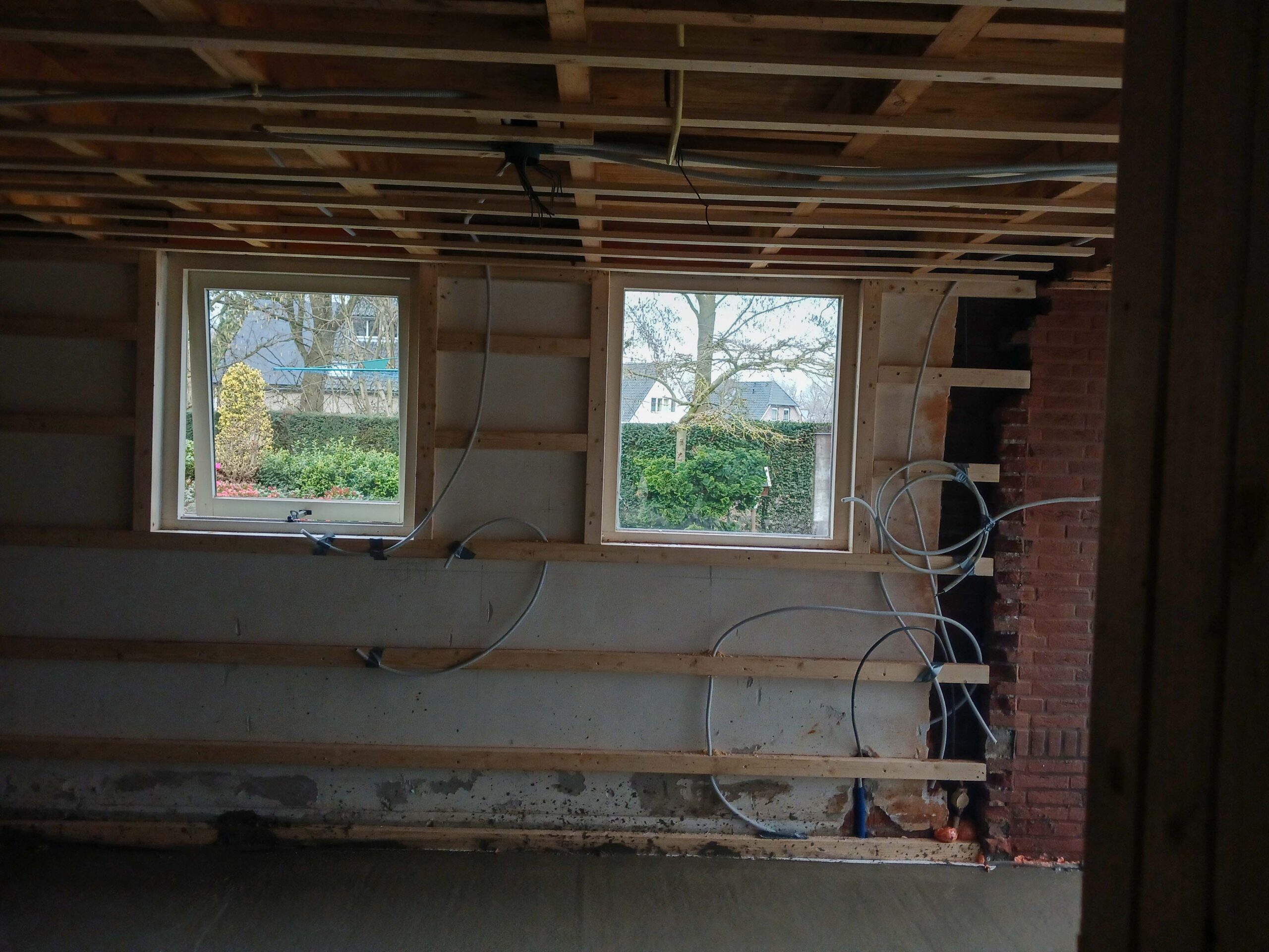 Houten wandconstructie met nieuwe kozijnen en leidingwerk tijdens de verbouwing van een woning in Eibergen
