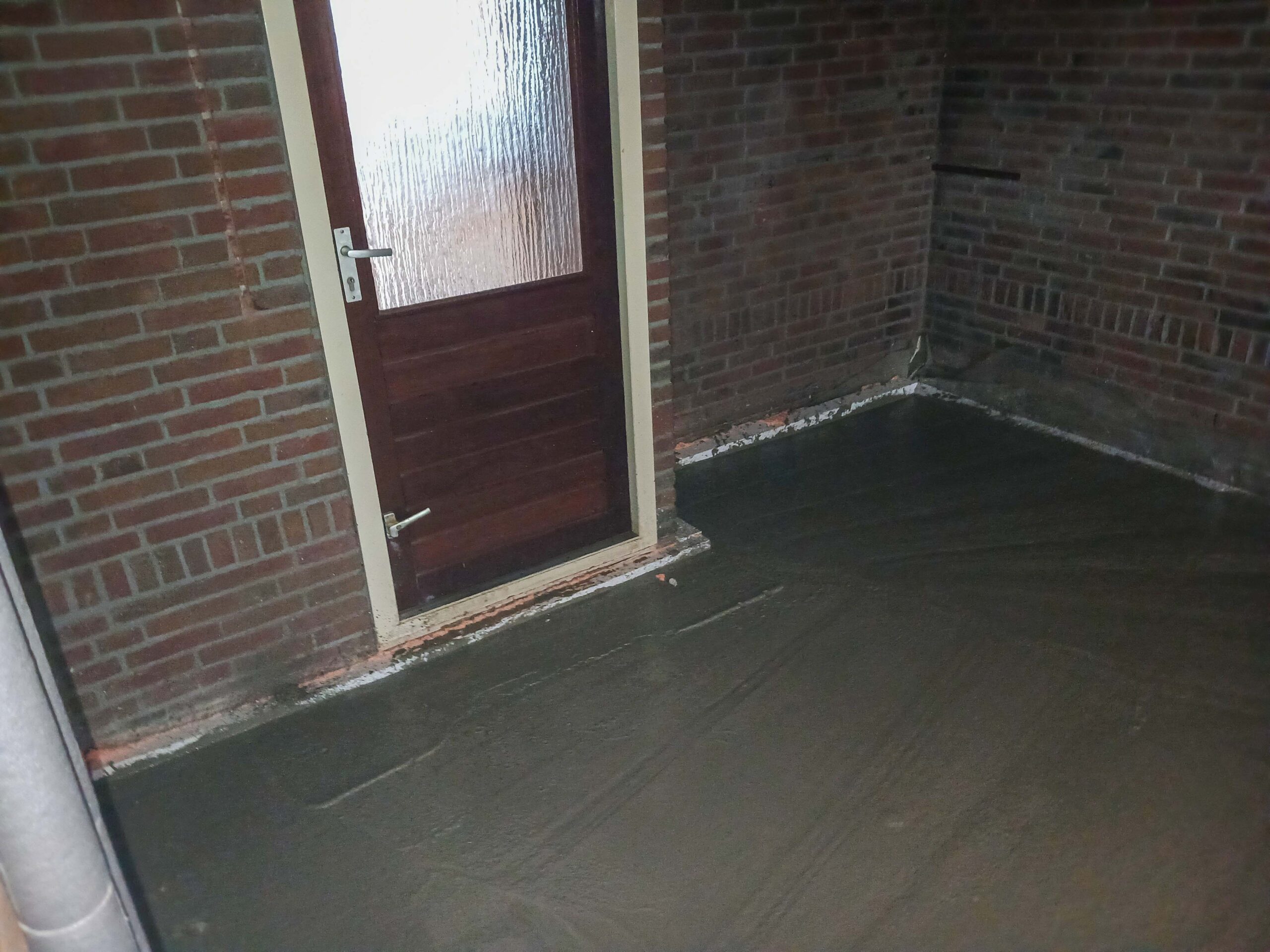 Nieuwe donkere dekvloer in de aanbouw van een woning in Eibergen