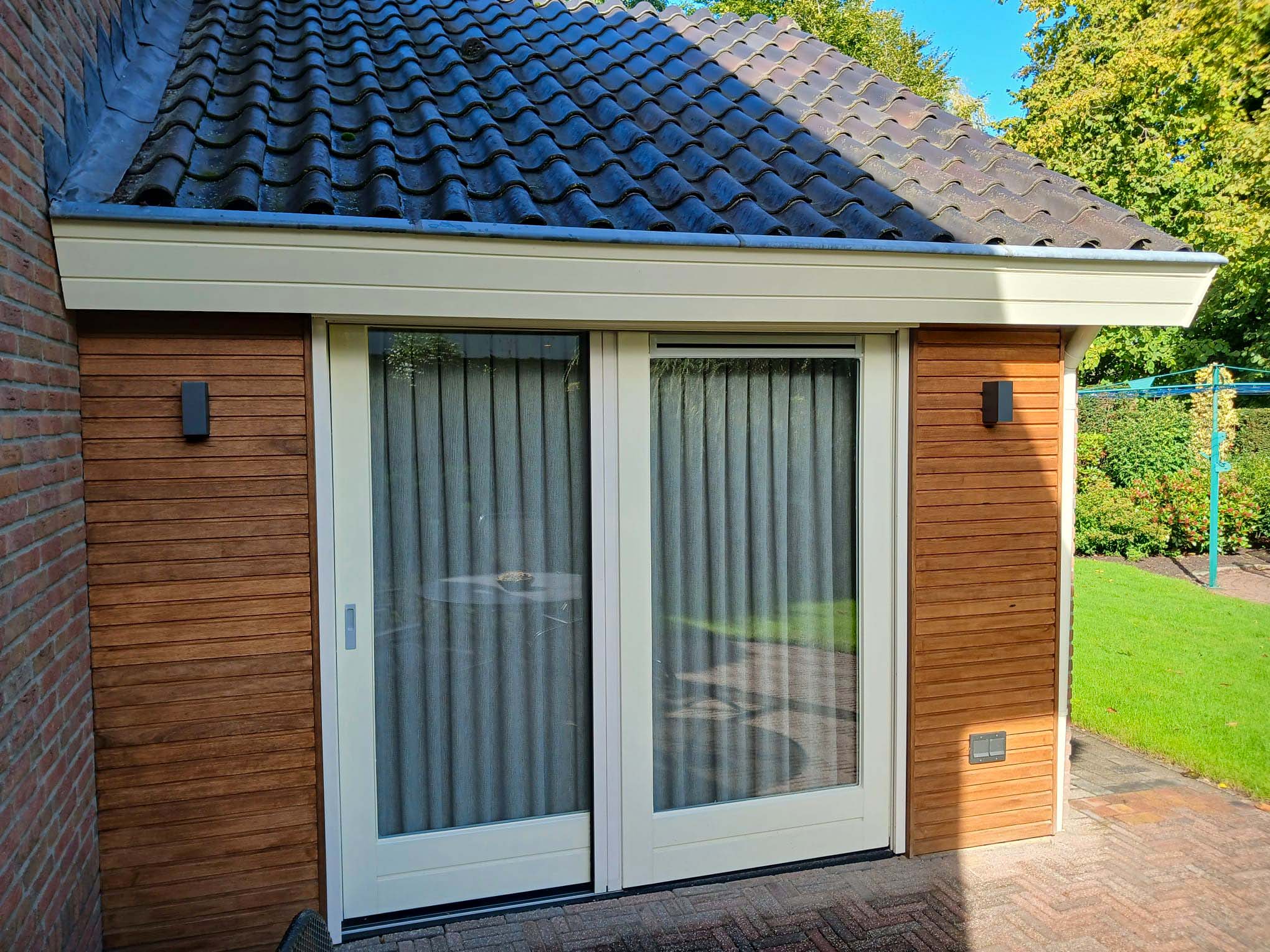 Schuifpui met houten gevelbekleding Eibergen Schuifpui met witte kozijnen en houten gevelbekleding aan de achterzijde van een woning in Eibergen
